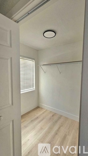 A small, empty room with a door and a window.