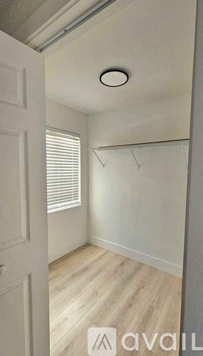 A small, empty room with a door and a window.