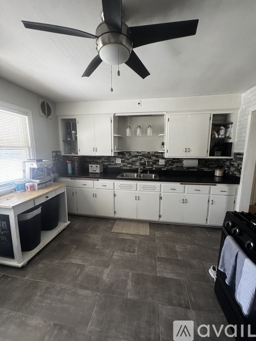 A kitchen with a fan and a black oven.