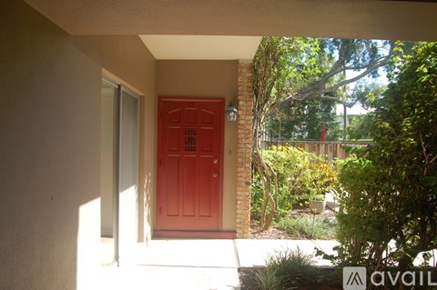 A red door is on the left side of a white wall.