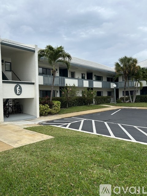 A parking lot in front of a building with a bicycle parked in the garage.