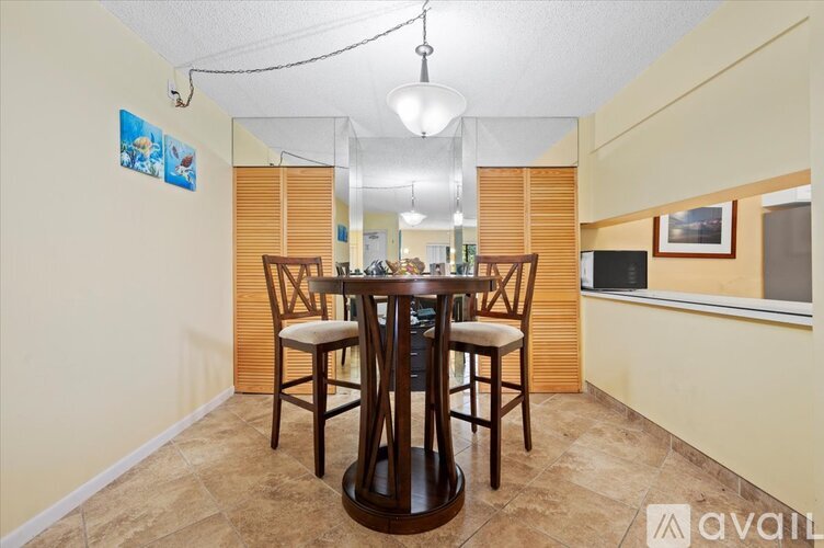 A dining room with a wooden table and chairs.