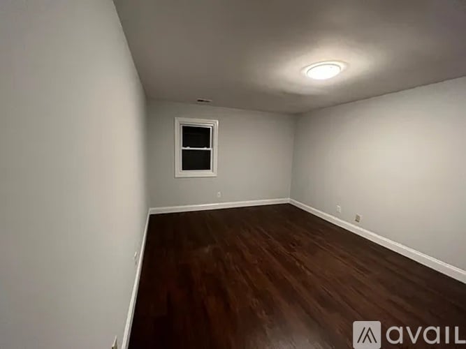 A room with a window and wooden flooring is available for rent.