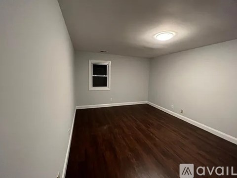 A room with a window and wooden flooring is available for rent.