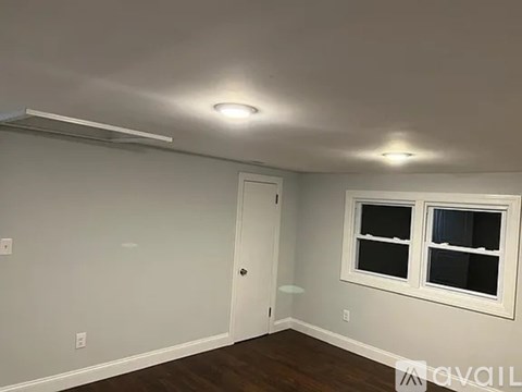 A room with a door, a window, and a light fixture on the ceiling.