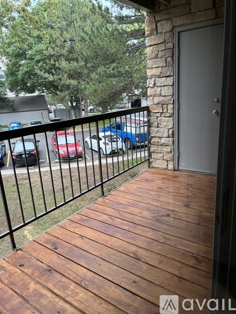 A balcony with a wooden floor and a black railing.