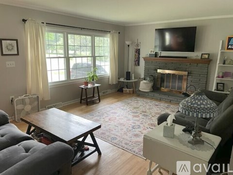 A living room with a fireplace and a television on the wall.