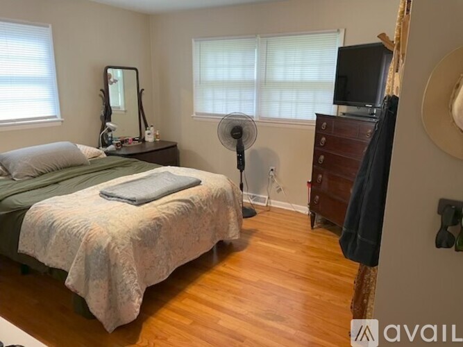 A bedroom with a bed, dresser, and mirror.