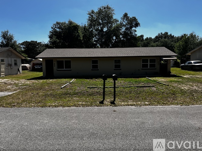 A house with a grey roof and a white fence is in the background.
