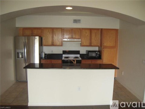 A kitchen with wooden cabinets and a black countertop.