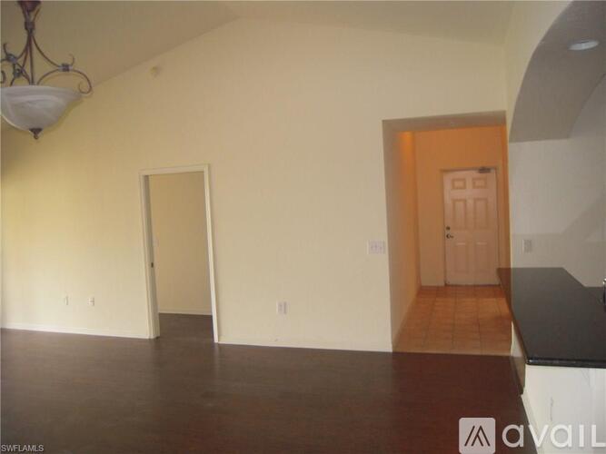 A room with a chandelier and a door on the right side.