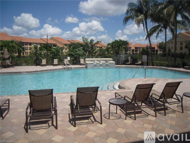 A pool surrounded by chairs and palm trees.