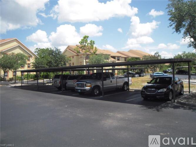 A parking lot with cars and a building in the background.