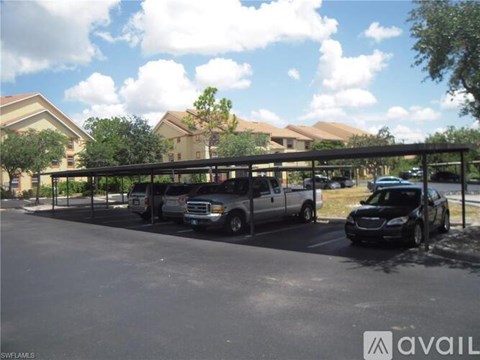 A parking lot with cars and a building in the background.