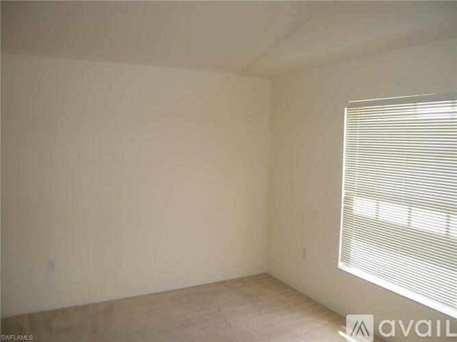 A room with a window covered by blinds.