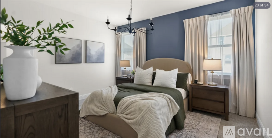 A bedroom with a bed, nightstand, and a plant on a dresser.
