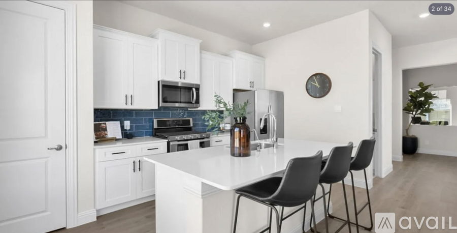 A modern kitchen with white cabinets and a large island.