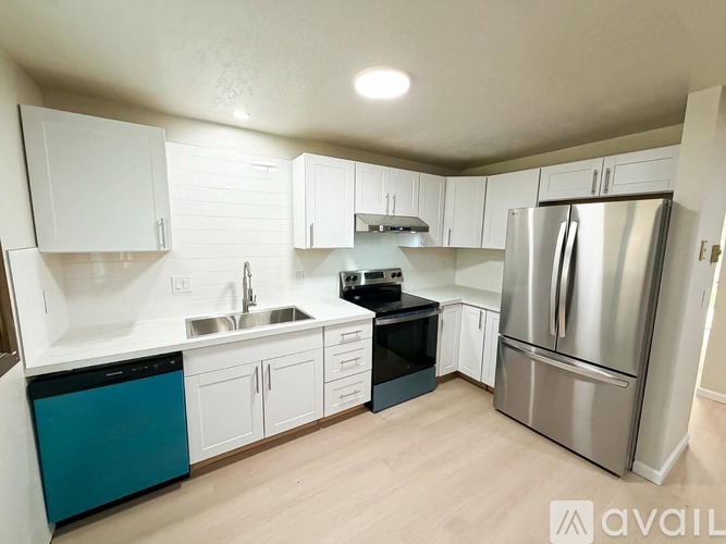 A kitchen with white cabinets and a stainless steel refrigerator.