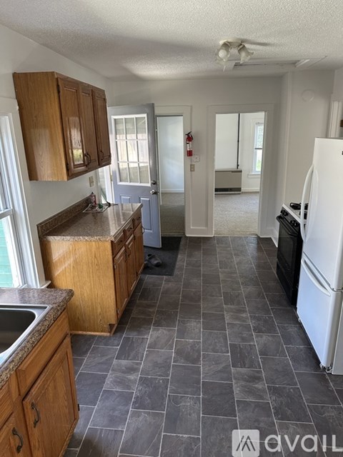 A kitchen with wooden cabinets and a white fridge.