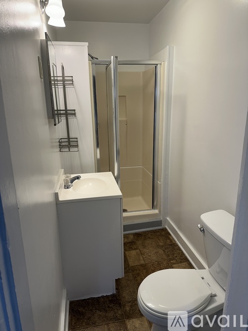 A bathroom with a toilet, sink, and shower.