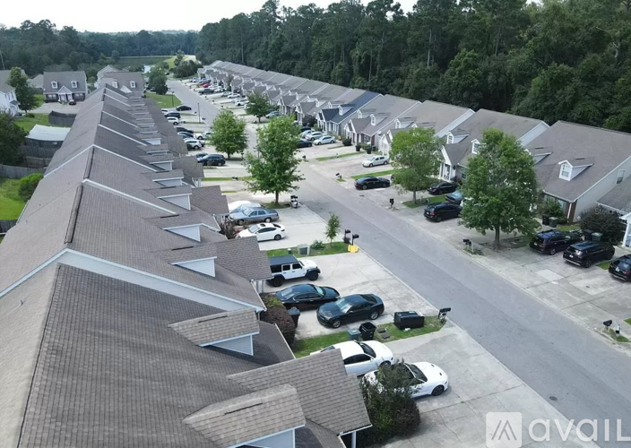 A row of houses with cars parked in front.