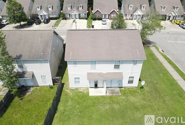 A house with a brown roof is surrounded by other houses.