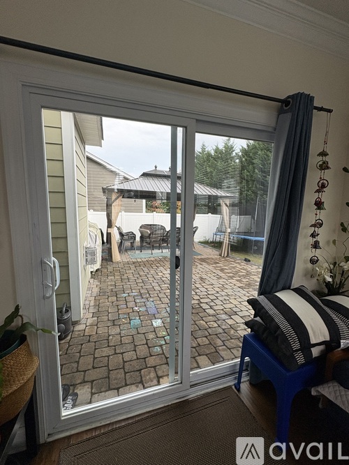 A patio with a table and chairs is visible through a sliding glass door.