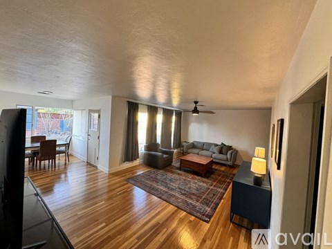 A living room with a grey couch and a wooden floor.