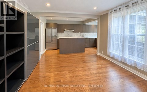 A spacious kitchen with wooden floors and a large island.