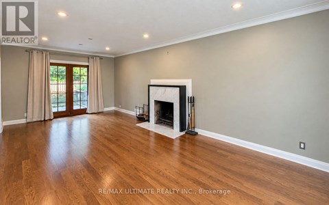 A spacious living room with a fireplace and hardwood floors.