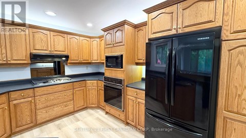 A kitchen with wooden cabinets and black appliances.