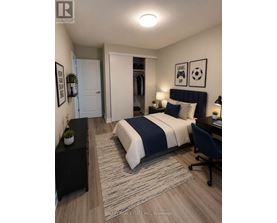 A bedroom with a bed, desk, and chair.