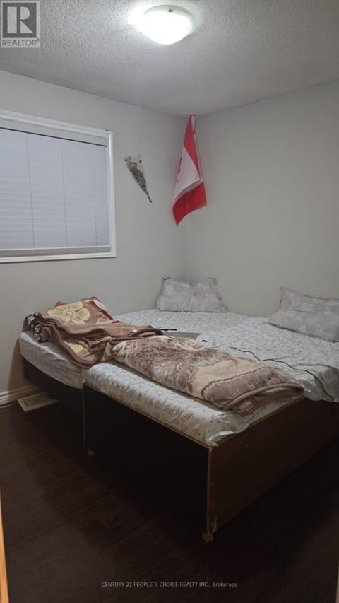 A bedroom with a bed and a flag on the wall.
