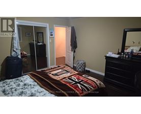 A bedroom with a bed, dresser, and mirror.