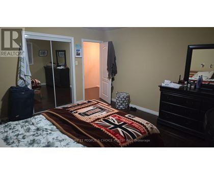 A bedroom with a bed, dresser, and mirror.