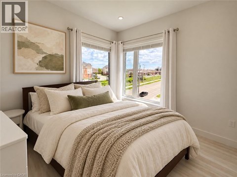 A bedroom with a large bed and a painting on the wall.