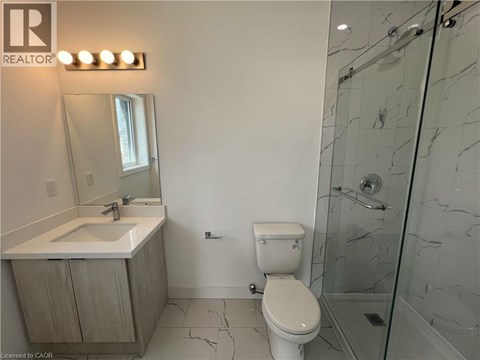 A bathroom with a toilet, sink, and shower.