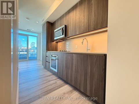 A kitchen with wood cabinets and a modern design.