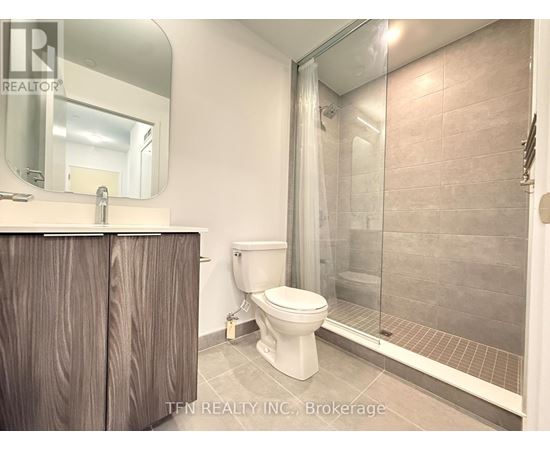 A bathroom with a toilet, sink, and shower.