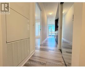 A hallway with a white wall and a wooden floor.