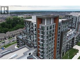 A modern multi-story building with a glass facade and a parking lot in front.
