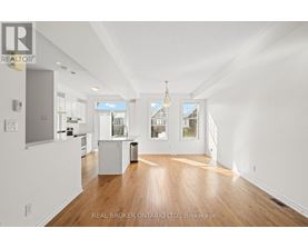 A spacious room with wooden floors and white walls.