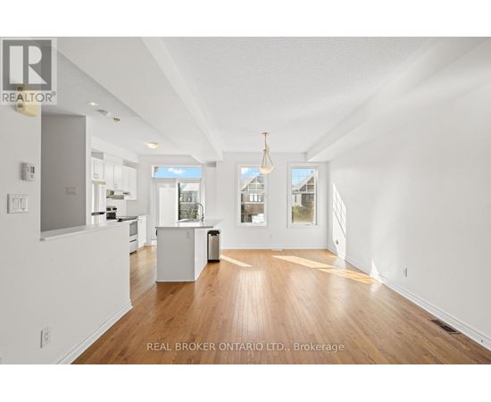 A spacious room with wooden floors and white walls.