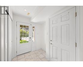 A white door with a glass window is in a room with white walls.