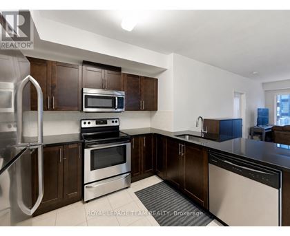 A kitchen with stainless steel appliances and wooden cabinets.