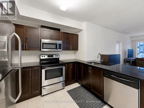 A kitchen with stainless steel appliances and wooden cabinets.