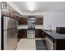 A kitchen with a stainless steel refrigerator, oven, and microwave.