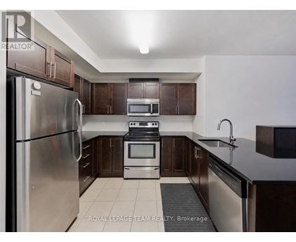 A kitchen with a stainless steel refrigerator, oven, and microwave.