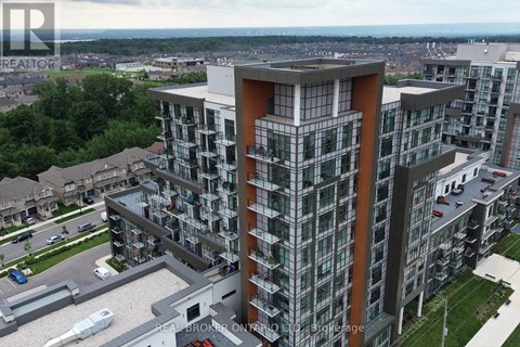 A modern multi-story residential building with balconies and a parking lot in front.