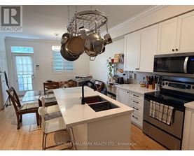 A kitchen with white cabinets and a large island with a sink.